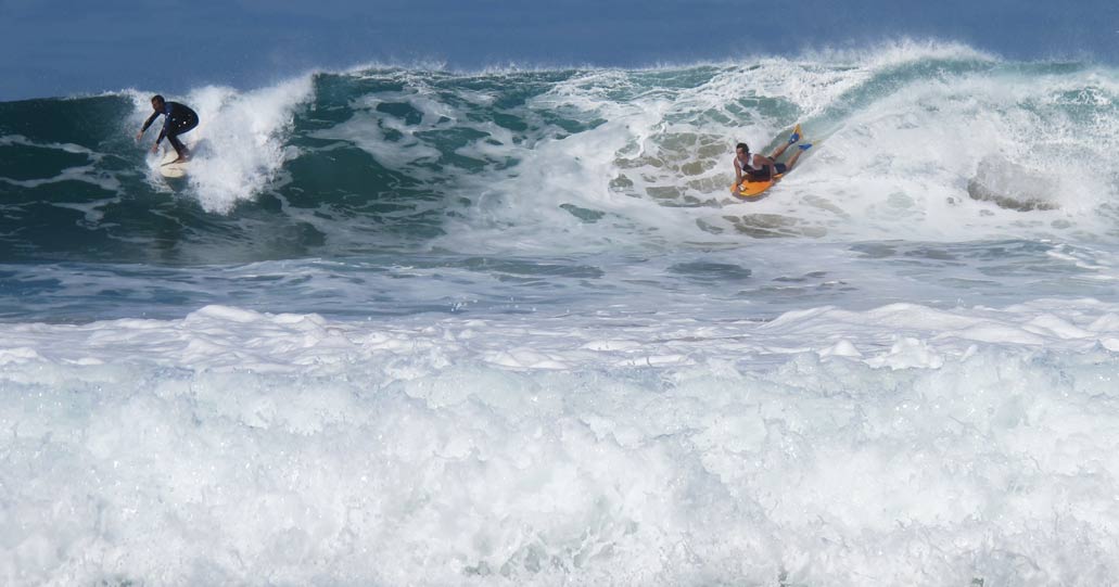 Fotografía de bodyboard y tabla de surf en la misma ola.
