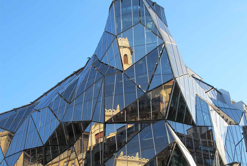 Fotografía de edificio moderno poliédrico de fachada de cristal en Bilbao. Sede de Osakidetza.