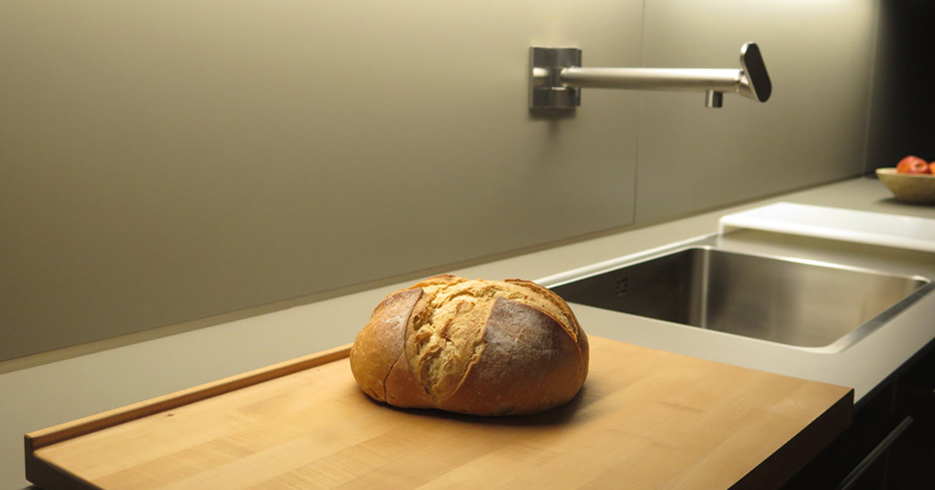 Fotografía de hogaza de pan de masa madre sobre encimera de cocina.
